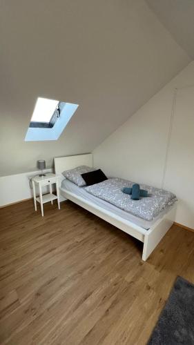 a white room with a bed and a table at Apartmenthaus Somborn in Bochum