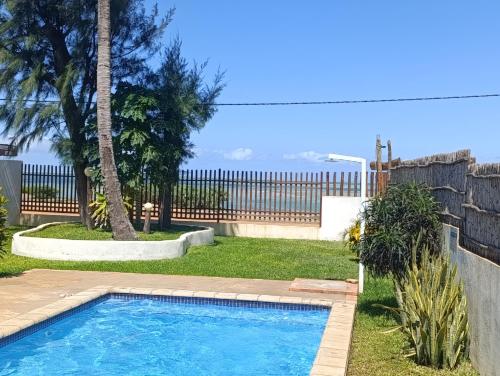 a swimming pool in a yard with a fence at Telvina Beach Lodge in Vilanculos