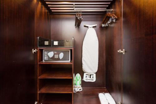 a bathroom with a shower with a tv and a towel at Radisson Bengaluru City Center in Bengaluru