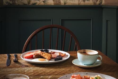 a table with a plate of food and a cup of coffee at The Pilsley Inn - Chatsworth in Baslow