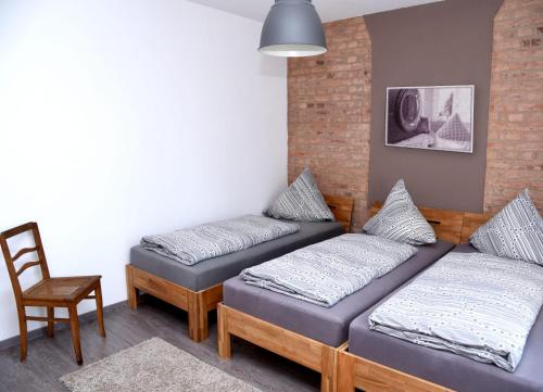 a room with two twin beds and a chair at Gästehaus Wagner in Chemnitz