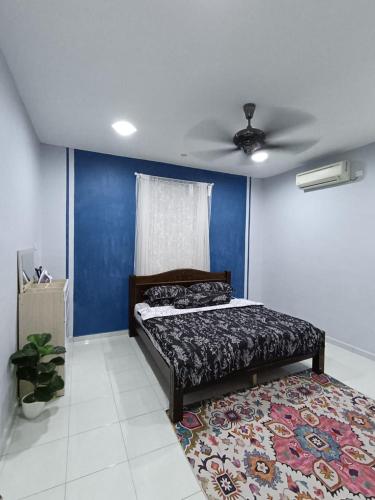 a bedroom with a bed and a blue wall at Ebnur Homestay in Arau