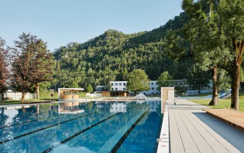 a swimming pool with a mountain in the background at Ferienwohnung iq-Sports in Bludenz