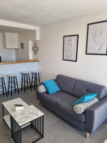 un salon avec un canapé bleu et une table dans l'établissement Naturiste Cap d'Agde Port Ambonne 204, au Cap d'Agde