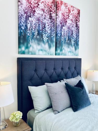 a bedroom with a bed with two paintings on the wall at Mandurah Oasis Retreat in Mandurah