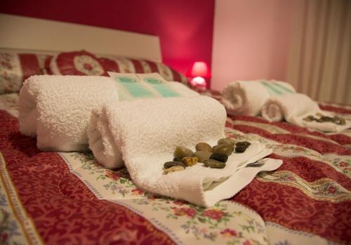 a pile of towels on a bed with at Case Saniela in Terrasini