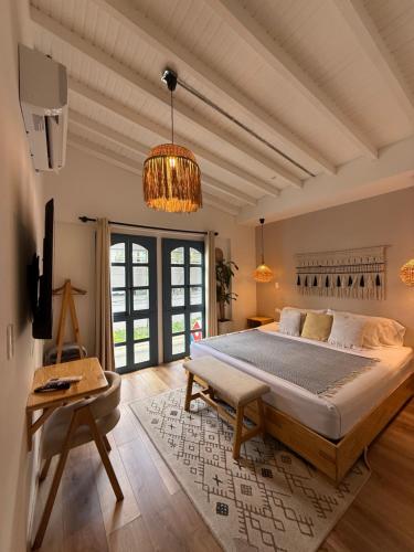 メデジンにあるPoblado Luum Boutique hotelの大きなベッドルーム(大型ベッド1台、シャンデリア付)