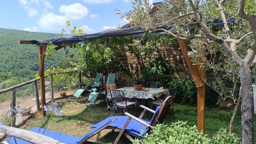 a patio with a table and chairs and a tree at Agriturismo Podere Tegline in Radda in Chianti