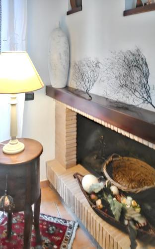 a fireplace in a living room with a lamp and a table at Charming House in Amelia with Lake View, 200 m² in Amelia