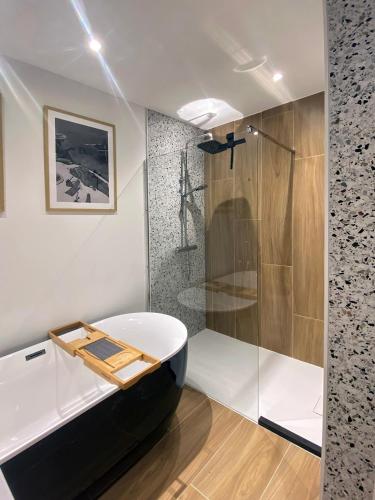 a bathroom with a bath tub and a shower at De bank van Nagele in Nagele
