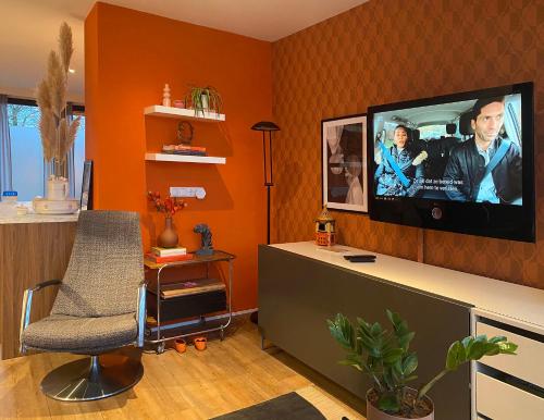 a living room with a flat screen tv on a wall at De bank van Nagele in Nagele