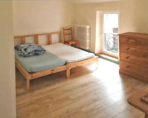 a bedroom with a bed and a dresser and a window at Maison spacieuse avec sauna à Héricy de 230 m² in Héricy