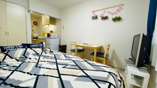 a bedroom with a bed and a kitchen with a table at 新所沢駅徒歩1分 近くに豊富な飲食店 ベルーナドーム 東京や川越観光拠点に コンビニ30秒 in Tokorozawa
