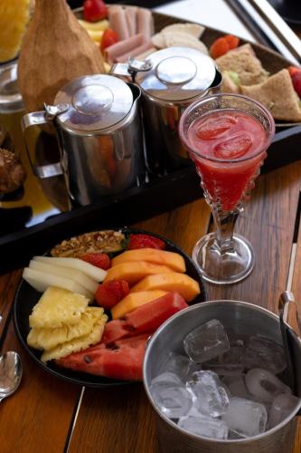 a table with a plate of food and a drink at Cataratas Park Hotel e Eventos in Foz do Iguaçu