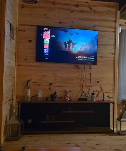 a flat screen tv on a wooden wall at Laslu in Punta Del Diablo