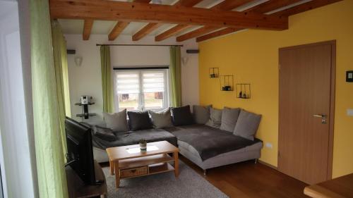 a living room with a couch and a television at Toskana in Klingenmünster