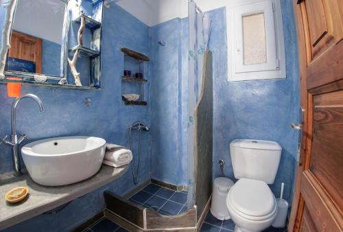 a blue bathroom with a sink and a toilet at Castria studios in Kionia