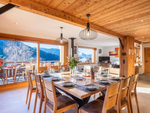 une salle à manger avec une grande table et des chaises en bois dans l'établissement Chalet 5 étoiles avec sauna et bain nordique, proche des pistes, pour 12 personnes - FR-1-467-127, au Grand-Bornand