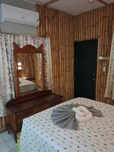 a bedroom with a bed with a mirror and a towel on it at Mom's Place Negril in Negril
