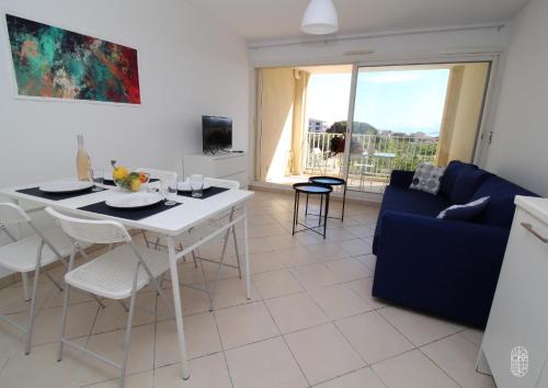 un salon avec une table et un canapé bleu dans l'établissement Appartement vue mer et montagnes, à LʼÎle-Rousse