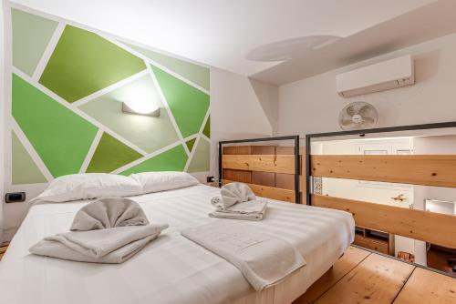 a bedroom with two beds and a green and white wall at Garden House Firenze - Careggi Meyer - Tramvia - 10 min dal Centro - Parcheggio vicinanze in Florence