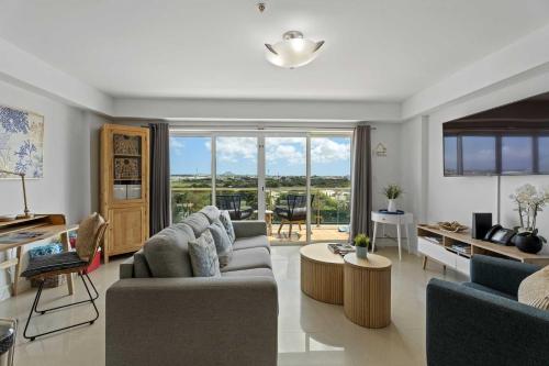 a living room with two couches and a table at Eagle Beach-Best value-Island View 1BR condo-R362 in Palm-Eagle Beach
