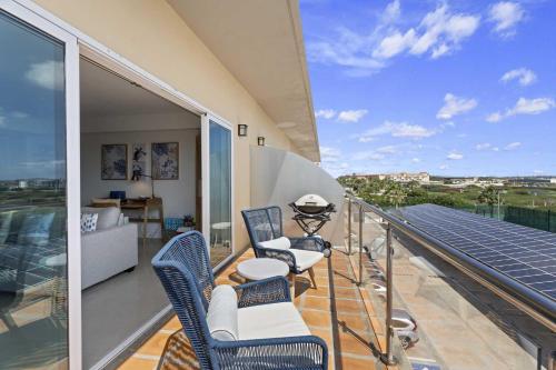 a balcony with chairs and a table on a roof at Eagle Beach-Best value-Island View 1BR condo-R362 in Palm-Eagle Beach