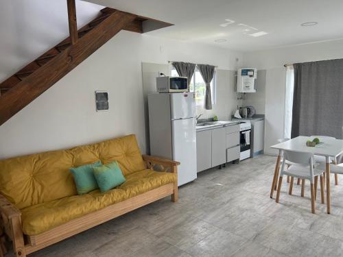 ein Wohnzimmer mit Sofa und eine Küche in der Unterkunft Complejo Las Cabañas del Lago in Mar de Cobo