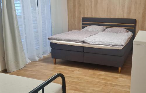 a bed in a room with a wooden floor at Apartmán Lesněnka in Říčky