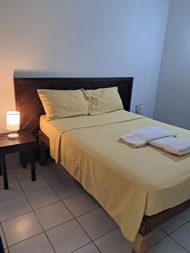 a bed with two towels on it in a bedroom at Mom's Place Negril in Negril