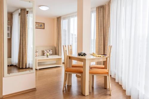 a dining room with a table and chairs and a mirror at Aparthotel Hotel Prestige City II in Primorsko