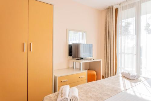 a hotel room with a bed and a tv at Aparthotel Hotel Prestige City II in Primorsko