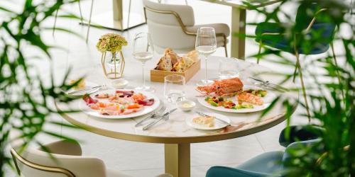 a table with plates of food and glasses of wine at Grand Hotel Victoria concept & spa, by R Collection Hotels in Menaggio
