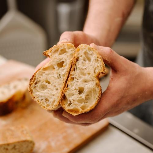 a person holding a piece of bread in their hands at Grand Hotel Victoria concept & spa, by R Collection Hotels in Menaggio