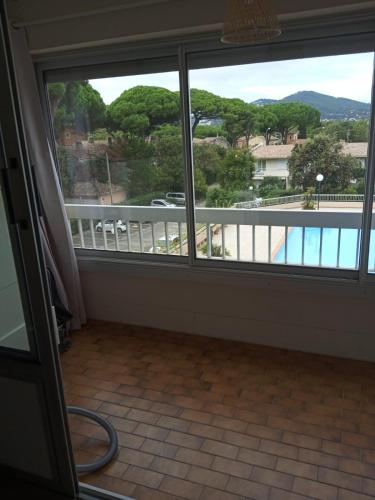 Cette chambre dispose d'une grande fenêtre donnant sur un balcon. dans l'établissement Port de Hyères, à Hyères