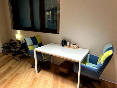 a white table and chairs in a room at Nomad Live Hostel in Busan
