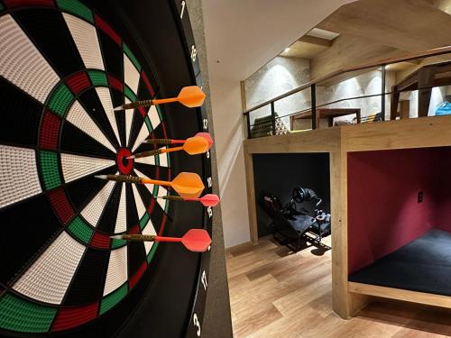 a dartboard in a living room next to a loft at Nomad Live Hostel in Busan