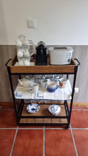 a shelf with cups and dishes on it at Casa da Beija - House Azores in Furnas