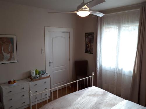 une chambre avec un lit et un ventilateur de plafond dans l'établissement Mostarlic Vegan and Gluten free B&B, à Bouconville