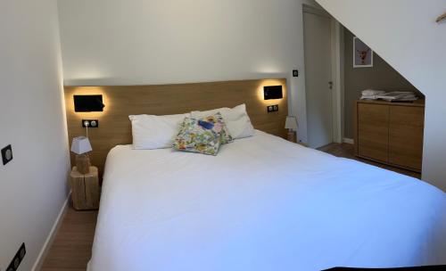 a bedroom with a large white bed with two pillows at Chalet Hygge Saint Lary - gîtes de standing en coeur de village des Pyrénées in Saint-Lary-Soulan