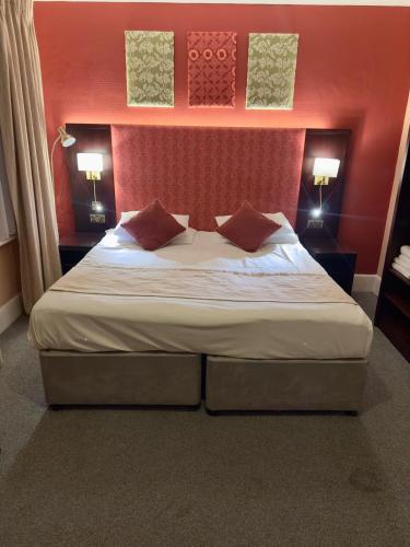 a bedroom with a large bed with red walls at Acacia Hotel in London