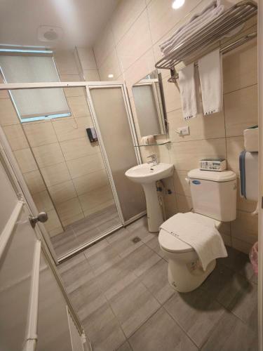 a bathroom with a toilet and a shower and a sink at 藍月金門民宿 in An-ch'ien