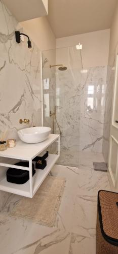 a white bathroom with a sink and a shower at Luxury Nobile Apartment with private parking in Opatija