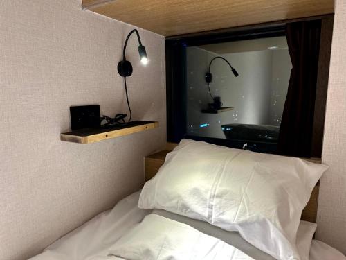a bedroom with a bed and a window with lights at Nomad Live Hostel in Busan