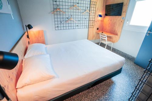 a bedroom with a bed and a chair in it at Greet hôtel Montpellier Aéroport Parc des Expos in Mauguio
