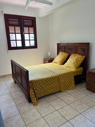 a bedroom with a bed with polka dot sheets at Ti Ken in Sainte-Luce