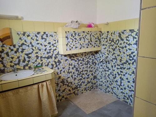 a bathroom with a sink and a mosaic wall at Villa de luxe avec piscine au soleil du sénégal petite cote in Mbour