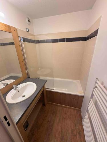 une salle de bain avec un lavabo et une baignoire dans l'établissement Appartement Orcières-Merlette Pied des Pistes Piscine By Kelly, à Orcières