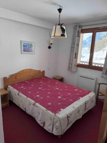 une chambre avec un grand lit avec une couverture rouge dans l'établissement Appartement Orcières-Merlette Pied des Pistes Piscine By Kelly, à Orcières