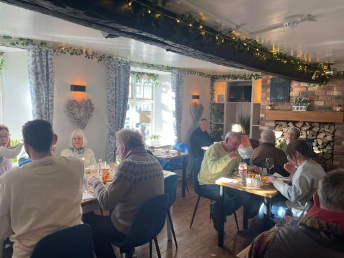 a group of people sitting at tables in a restaurant at The Fox Inn, Wilbarston in Wilbarston